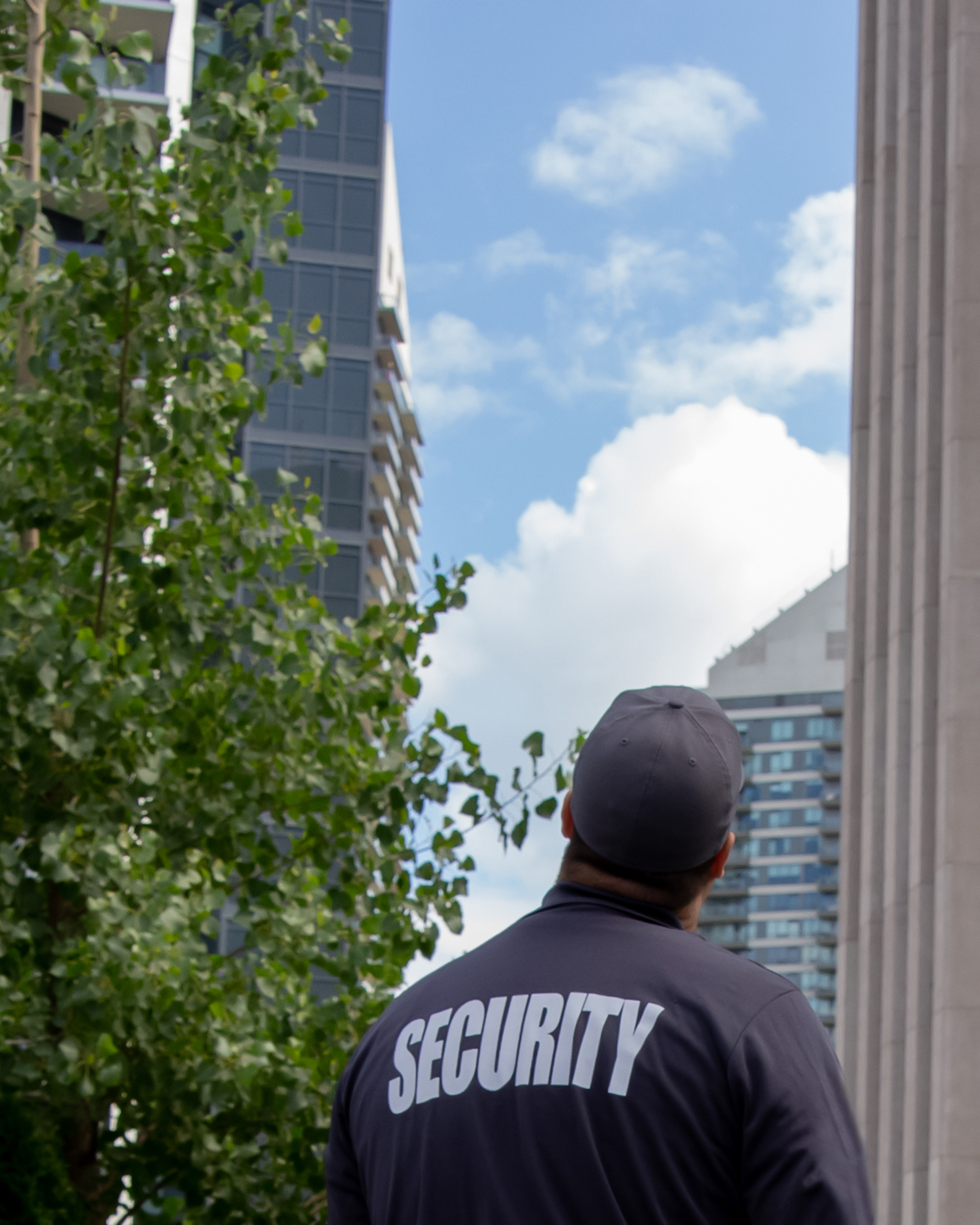 Security guard looking at tall buildings